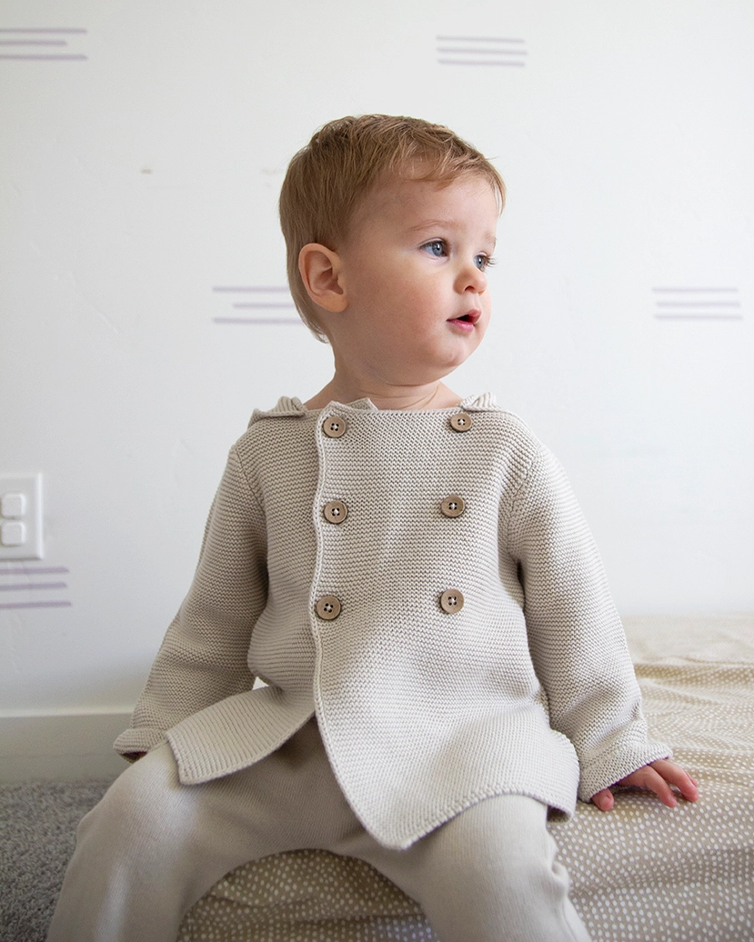 Hooded Double Button Baby Jacket, Stone Organic Cotton this Sweater Shown in 6 to 12 months.
Call for available Sizes, 303-744-7464